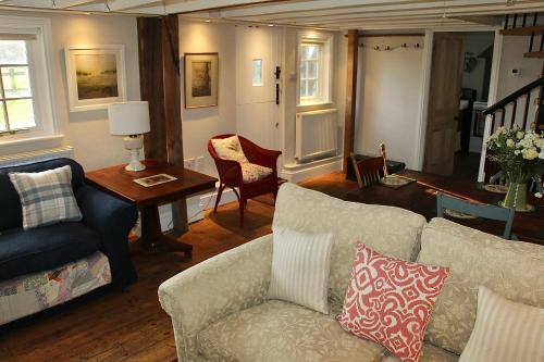 a living room with a couch and a table at Bessie May Cottage in Beaulieu