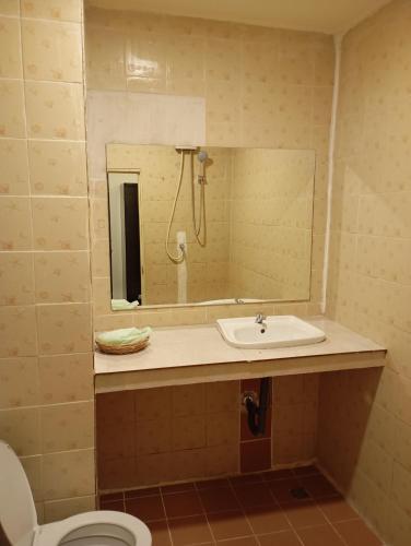 a bathroom with a sink and a mirror and a toilet at Buddy hotel in Pattaya