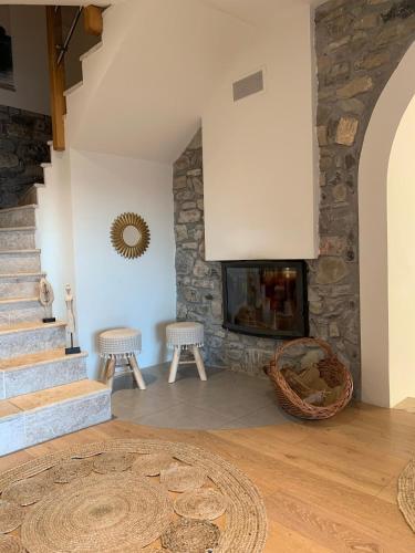 - un salon avec une cheminée en pierre et deux tabourets dans l'établissement Chalet proche station Reallon 12 personnes, à Saint-Apollinaire