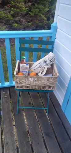 einem Korb mit Produkten auf einer blauen Bank in der Unterkunft Les roulottes de Joséphine in Veyrines-de-Domme
