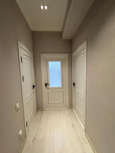 an empty room with two doors and a window at Apart Khujand in Khujand
