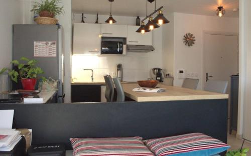 - une cuisine avec une table et un comptoir dans l'établissement A l'Orée du Bois, à Audenge