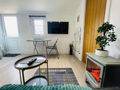 TV a/nebo společenská místnost v ubytování Heathrow Airport 10 mins drive l FREE SECURE PARKING l Tiny House with Courtyard