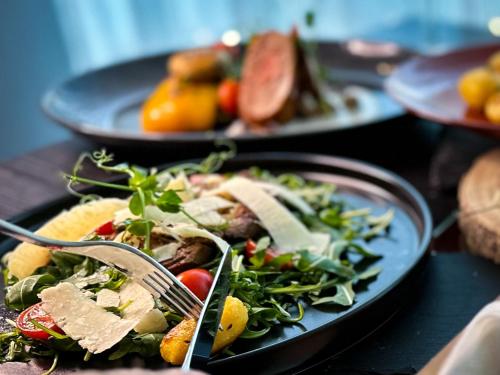 a plate of salad with a fork on a table at Hotel Modena in Bratislava