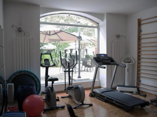 a room with a gym with exercise equipment and an umbrella at Hotel Le Galambre in Nîmes