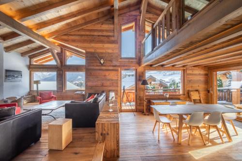 un grand salon avec une table et des chaises dans l'établissement Chalet Les Marmottes, à Combloux