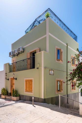 a green building with a balcony on top of it at Vila Origens Boutique Hotel Albufeira – Adults Only in Albufeira