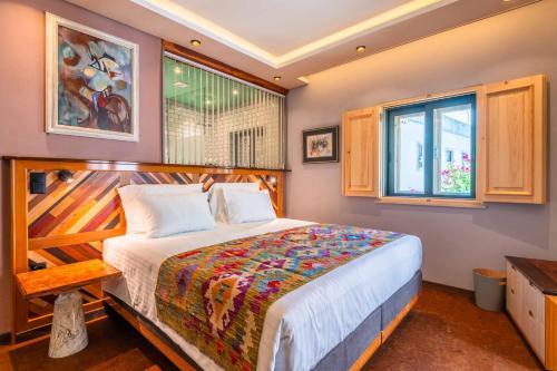 a bedroom with a bed and a window at Vila Origens Boutique Hotel Albufeira – Adults Only in Albufeira