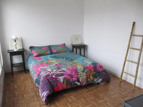 une chambre avec un lit avec une couette colorée dans l'établissement APPARTEMENT AU COEUR D'Huelgoat, à Huelgoat