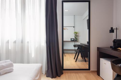 a mirror in a room with a bed and a desk at Athens Tower in Athens
