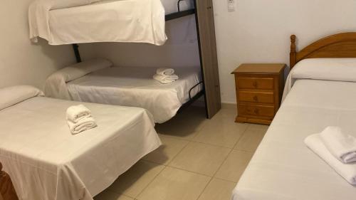 a hotel room with two beds and towels at Hospedium DLJ Hostal Ben Nassar in Arjona