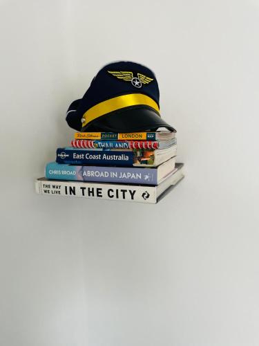 a stack of books with a hat on top at Heathrow Airport 10 mins drive l FREE SECURE PARKING l Tiny House with Courtyard in New Bedfont