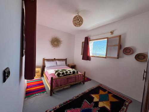 a bedroom with a bed and a colorful rug at Fisherman house rooms in Wassane