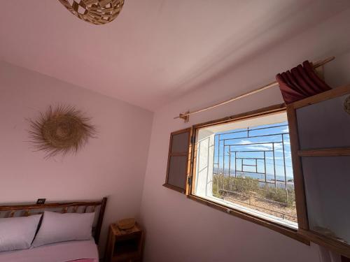 a bedroom with a window with a view of the ocean at Fisherman house rooms in Wassane