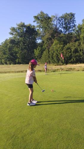 a young girl playing golf on a golf course at Hotel Golf Bitozeves in Bitozeves