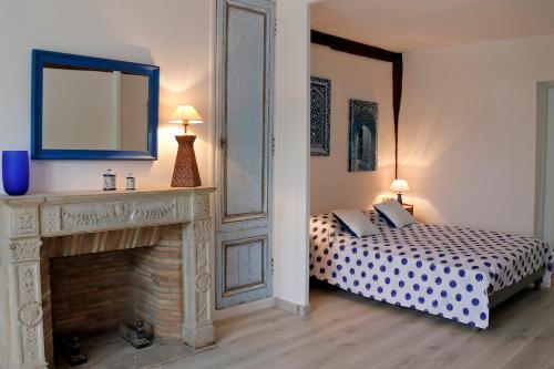 - une chambre avec un lit, une cheminée et un miroir dans l'établissement La Citadine, Historic Townhouse, views of Royal Château of Amboise, AC, Parking, à Amboise