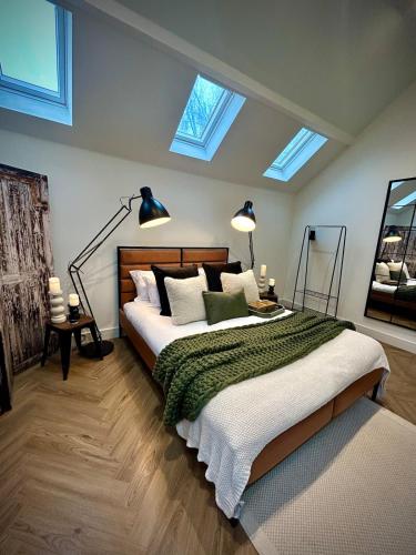 a bedroom with a bed and two skylights at The Oven House-Wyndale Living - Malvern Hills in Great Malvern