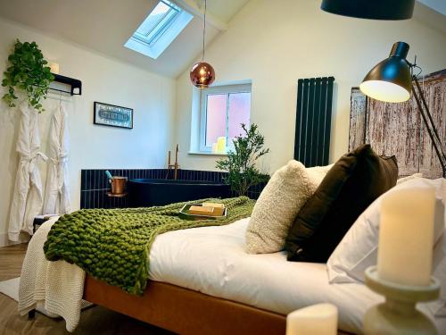 a bedroom with a bed with a green blanket on it at The Oven House-Wyndale Living - Malvern Hills in Great Malvern