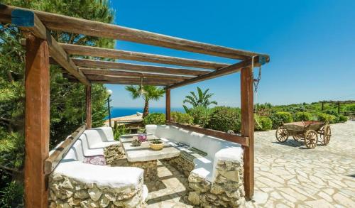 a wooden pergola with a table and chairs on a patio at Villa Poseidon Residence in Skinária