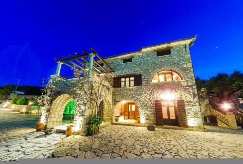 a large stone building at night with lights at Villa Poseidon Residence in Skinária