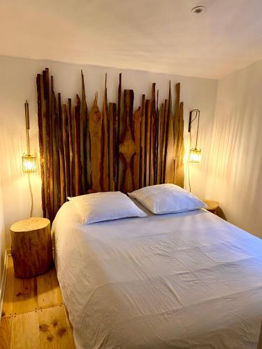 une chambre avec un lit avec une grande tête de lit en bois dans l'établissement La balinaise, à Évenos