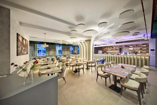 a restaurant with wooden tables and chairs and flowers at lyf Schönbrunn Vienna in Vienna