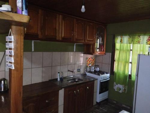 a kitchen with wooden cabinets and a white stove top oven at 7copas in Puerto Iguazú