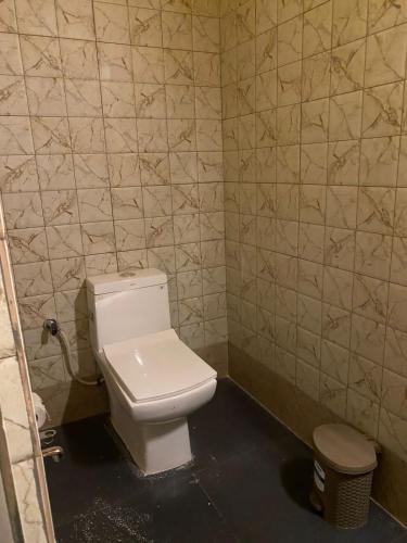 a bathroom with a white toilet in a room at Lemonwood cottage in North Lakhimpur