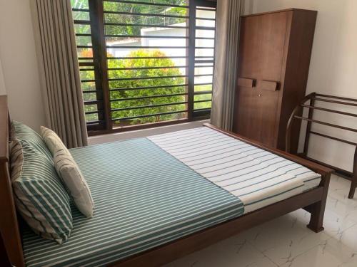 a bed in a room with a large window at Villa Rukaththana UNAKURUWA in Tangalle