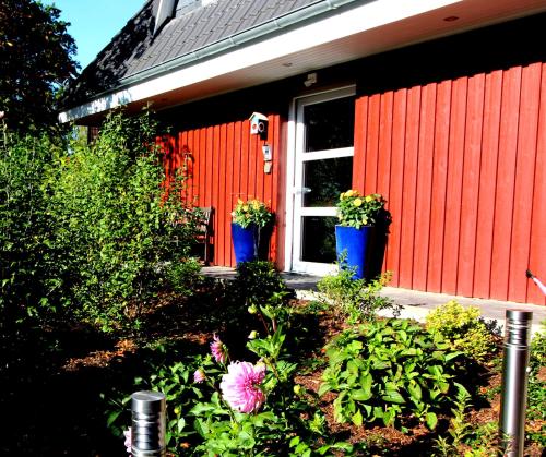 two potted plants on the side of a red house at Apartment HH West modern und komfortabel in Hamburg