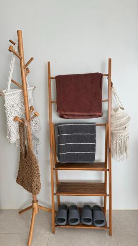 a towel rack with towels and shoes on a shelf at Patong Sea View pool view condo in Patong Beach