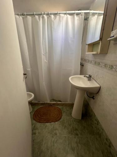 a bathroom with a white shower curtain and a sink at CaSaBELLa in La Floresta