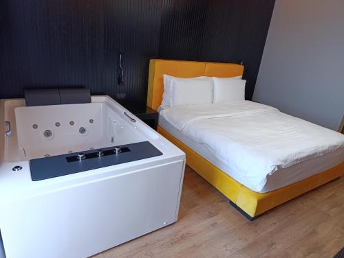 a bathroom with a bath tub next to a bed at Toka Hotel Restaurant in Pogradec