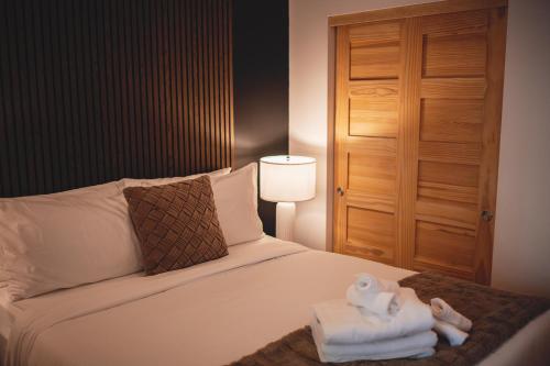 a bedroom with a bed with towels on it at Villa Experience Nature Le Nid in Saint-Irénée