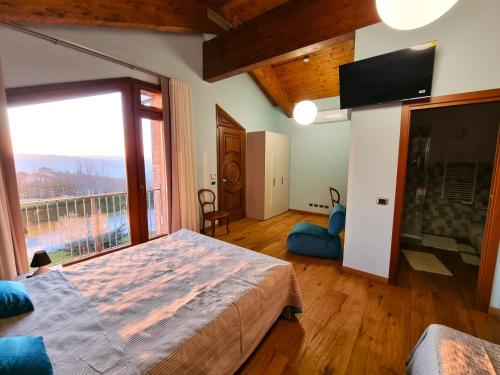 a bedroom with a large bed and a large window at Ca 'nsel Bric in Canelli