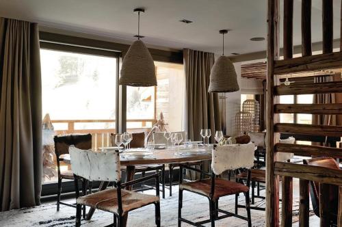 - une salle à manger avec une table, des chaises et des verres à vin dans l'établissement Chalet Le Prariand - Megève, à Megève