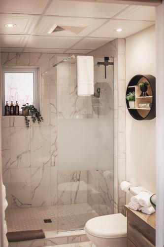 a bathroom with a glass shower with a toilet at Villa Experience Nature Le Nid in Saint-Irénée