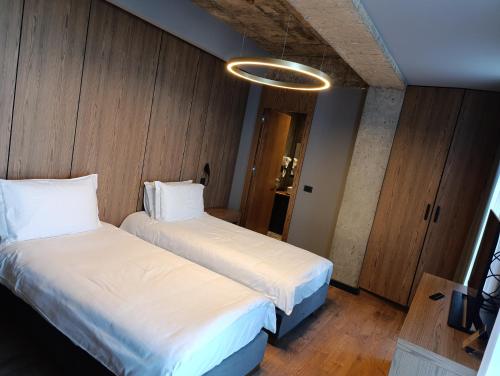 two beds in a room with wooden walls at Toka Hotel Restaurant in Pogradec