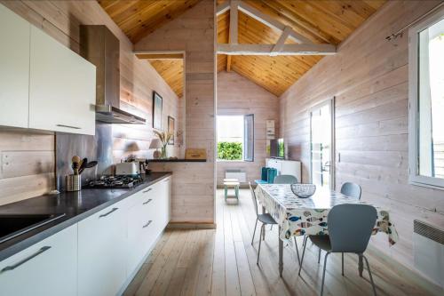 une cuisine avec une table et des chaises dans une pièce dans l'établissement La Cabane 18 petit cocon de rêve, à Andernos-les-Bains