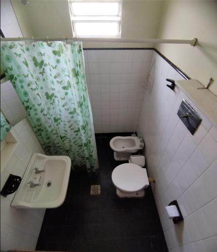 a bathroom with two toilets and a sink and a shower at Deptos Pablos, Apto No 3 in Villa Gesell