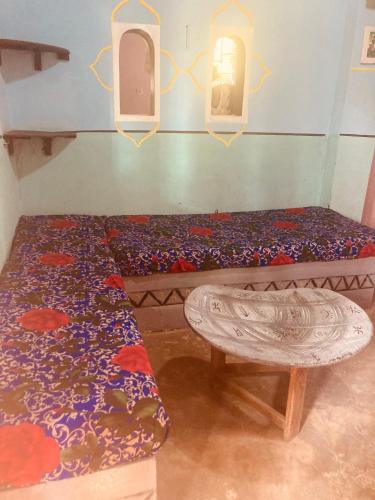 a room with a bed and a bench and a window at Auberge Culturelle Les Belles Etoiles in Abene