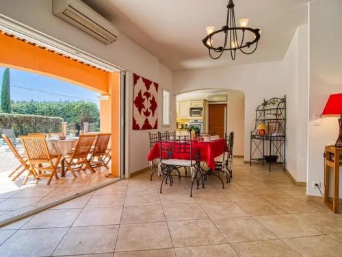 une salle à manger avec une table et des chaises rouges dans l'établissement Villa Faro Provence Var, à Montfort-sur-Argens