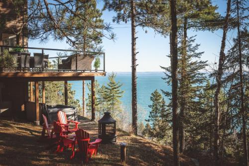 a view of the ocean from the porch of a house at Villa Experience Nature Le Nid in Saint-Irénée