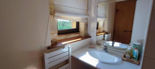 a bathroom with two sinks and a window in it at Domaine de Périer in Cénac-et-Saint-Julien