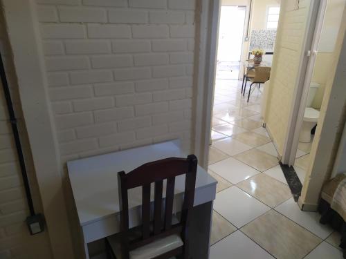 a room with a table and a chair in a hallway at Pousada - Flat - Kitnet - Mobiliada, Confortável e Perto de Tudo in Atibaia