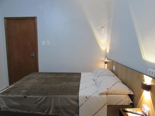 a bedroom with a bed with pillows on it at Hotel Tropicália próximo a 25 de março , Brás e Bom Retiro "Com estacionamento conveniado ao lado do hotel" in Sao Paulo