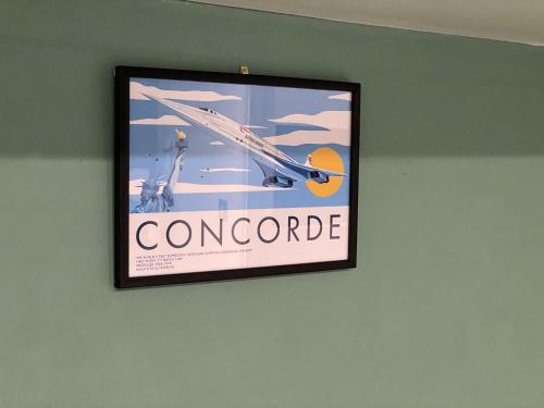 a poster of a plane hanging on a wall at Heathrow Airport 10 mins drive l FREE SECURE PARKING l Tiny House with Courtyard in New Bedfont