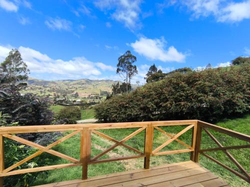 a wooden bridge with a view of the hills at Glamping con jacuzzi La Terraza del cielo in Chocontá
