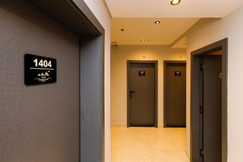 a hallway with four doors and a sign on the wall at DAR Pyramids View Inn - Rooftop in Cairo