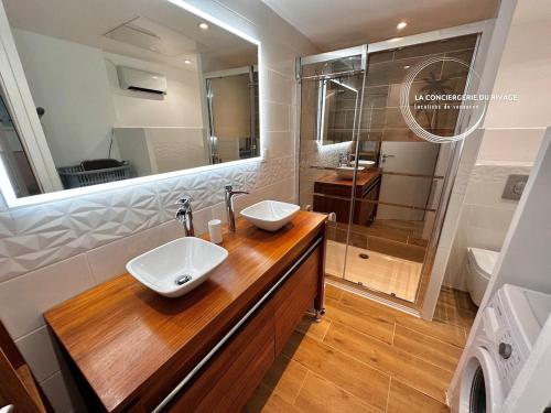 une salle de bain avec deux lavabos et une douche dans l'établissement Le Malibu - Port de Carqueiranne - Tout à pied, à Carqueiranne